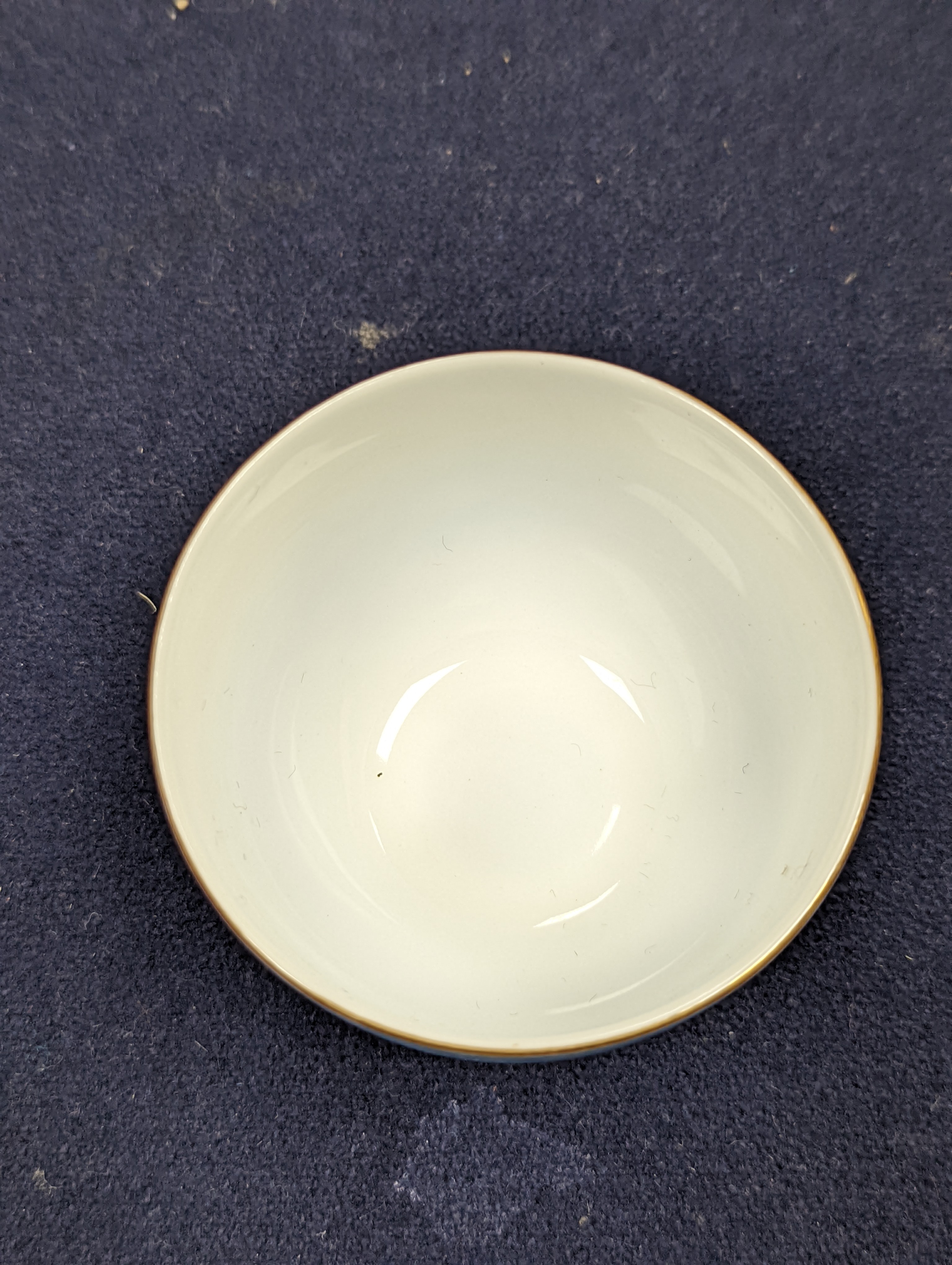 A Japanese or Chinese sgrafitto blue enamelled cup, cased. 6cm diameter